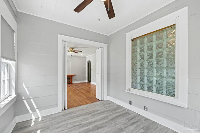 a view of empty room with wooden floor and window
