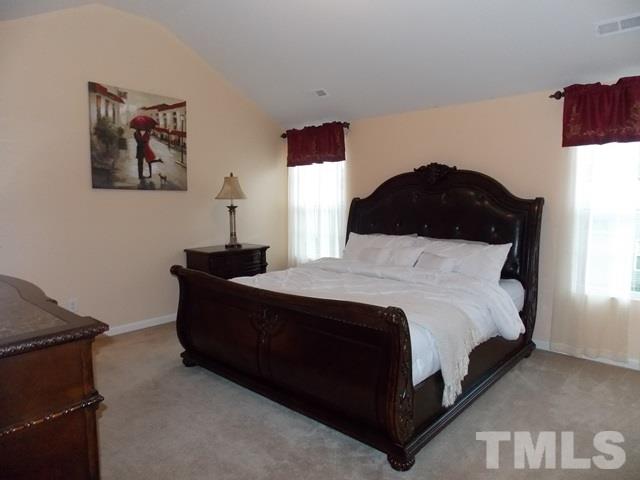 1621 Extine Lane Raleigh, NC 27610 - Photo 11 of 25 a large bed sitting in a bedroom next to a window