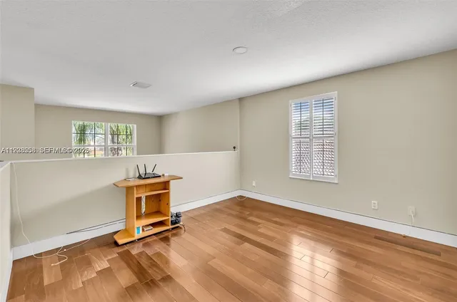 a view of a hallway and a dining room with wooden floor