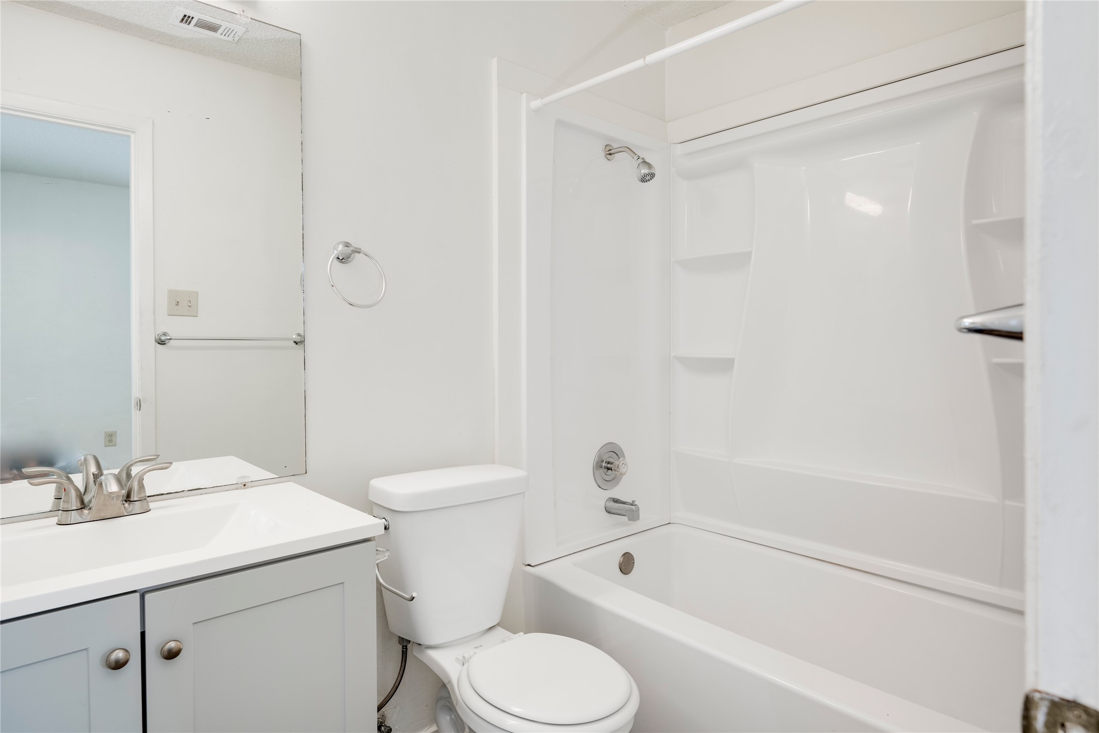 7918 West Gate Boulevard Austin, TX 78745 - Photo 10 of 31 A pristine bathroom features a single vanity, clean commode, and a shower-tub combination for comfort.