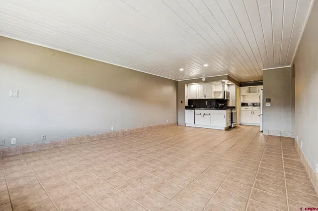 a view of empty room with kitchen