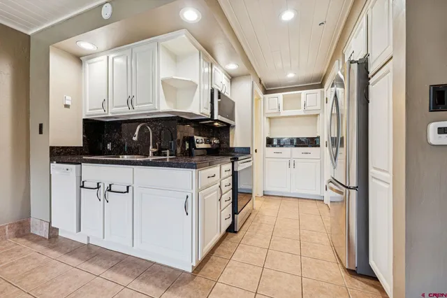 a kitchen with stainless steel appliances granite countertop a refrigerator and a stove