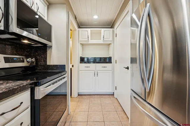 a kitchen with stainless steel appliances granite countertop a refrigerator and a stove