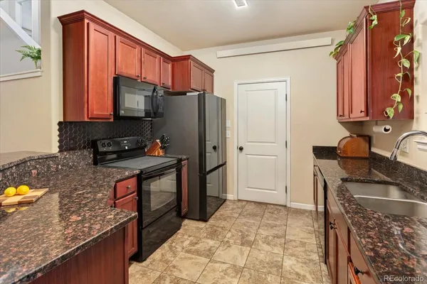 a kitchen with stainless steel appliances granite countertop a refrigerator stove and sink