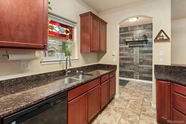 a kitchen with granite countertop a sink and a stove