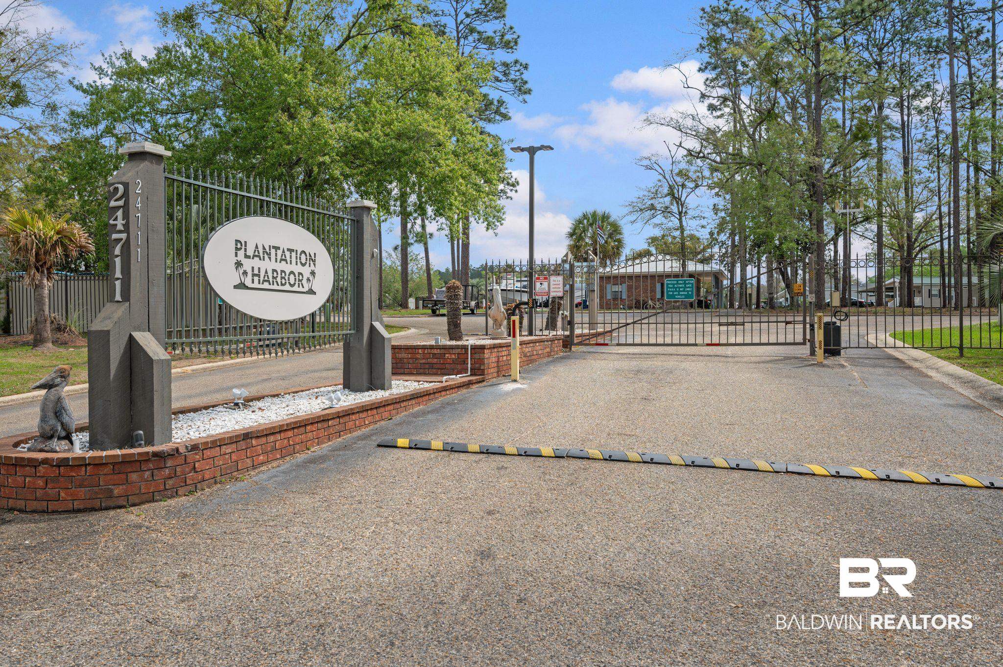 24711 County Road 20, Unit A11 Elberta, AL 36530 - Photo 33 of 35 View of asphalt street with a speed bump, a gate, a gated entry, and curbs