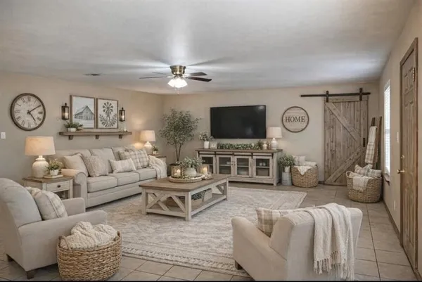 a living room with furniture a clock and a flat screen tv
