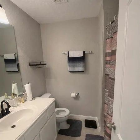 a bathroom with a toilet sink and mirror