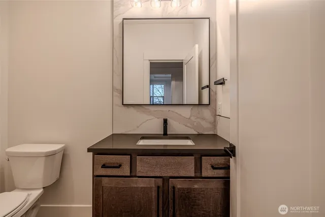 a bathroom with a toilet sink and mirror