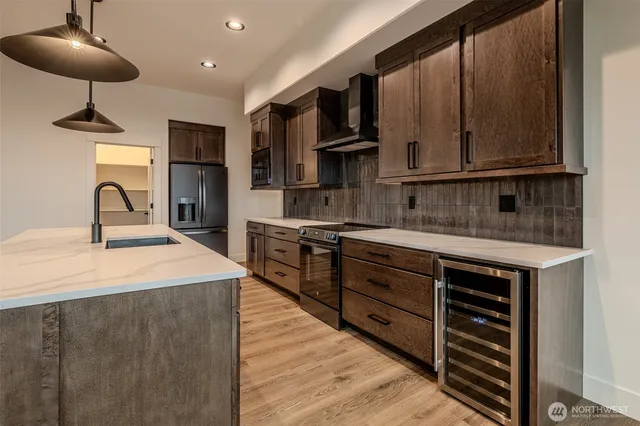 a kitchen with stainless steel appliances granite countertop a sink a stove and a refrigerator