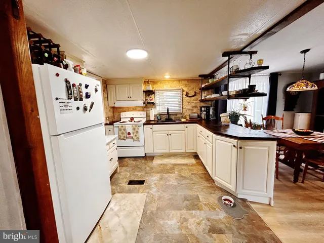 a kitchen with granite countertop a refrigerator and a sink