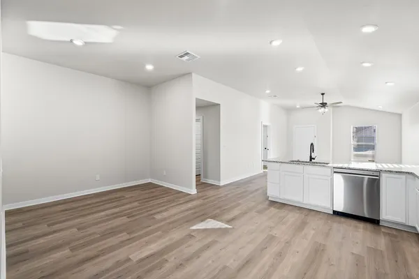 a large kitchen with stainless steel appliances a large counter top and a wooden floors