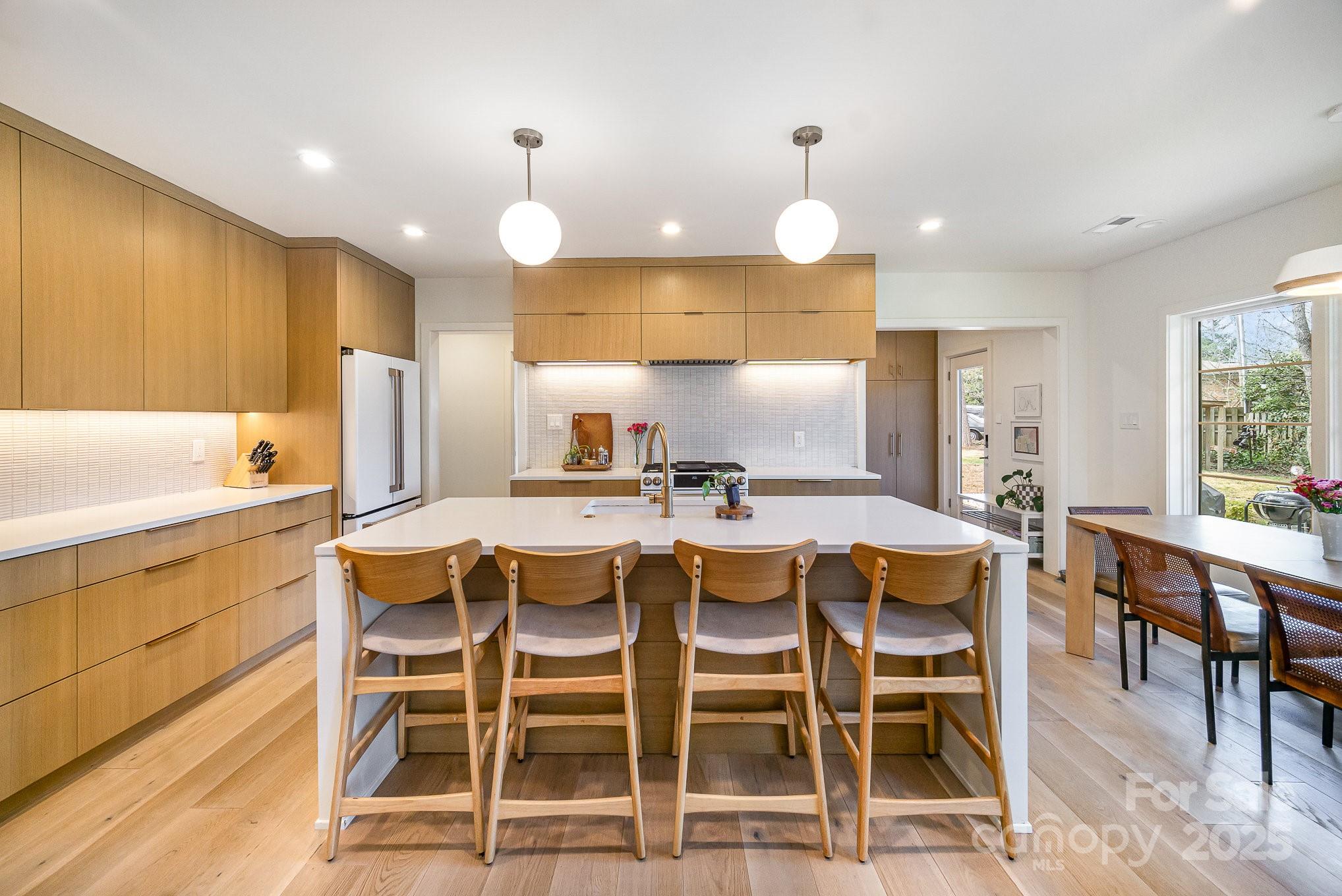 4833 Addison Drive Charlotte, NC 28211 - Photo 18 of 47 a kitchen with kitchen island granite countertop cabinets table and chairs