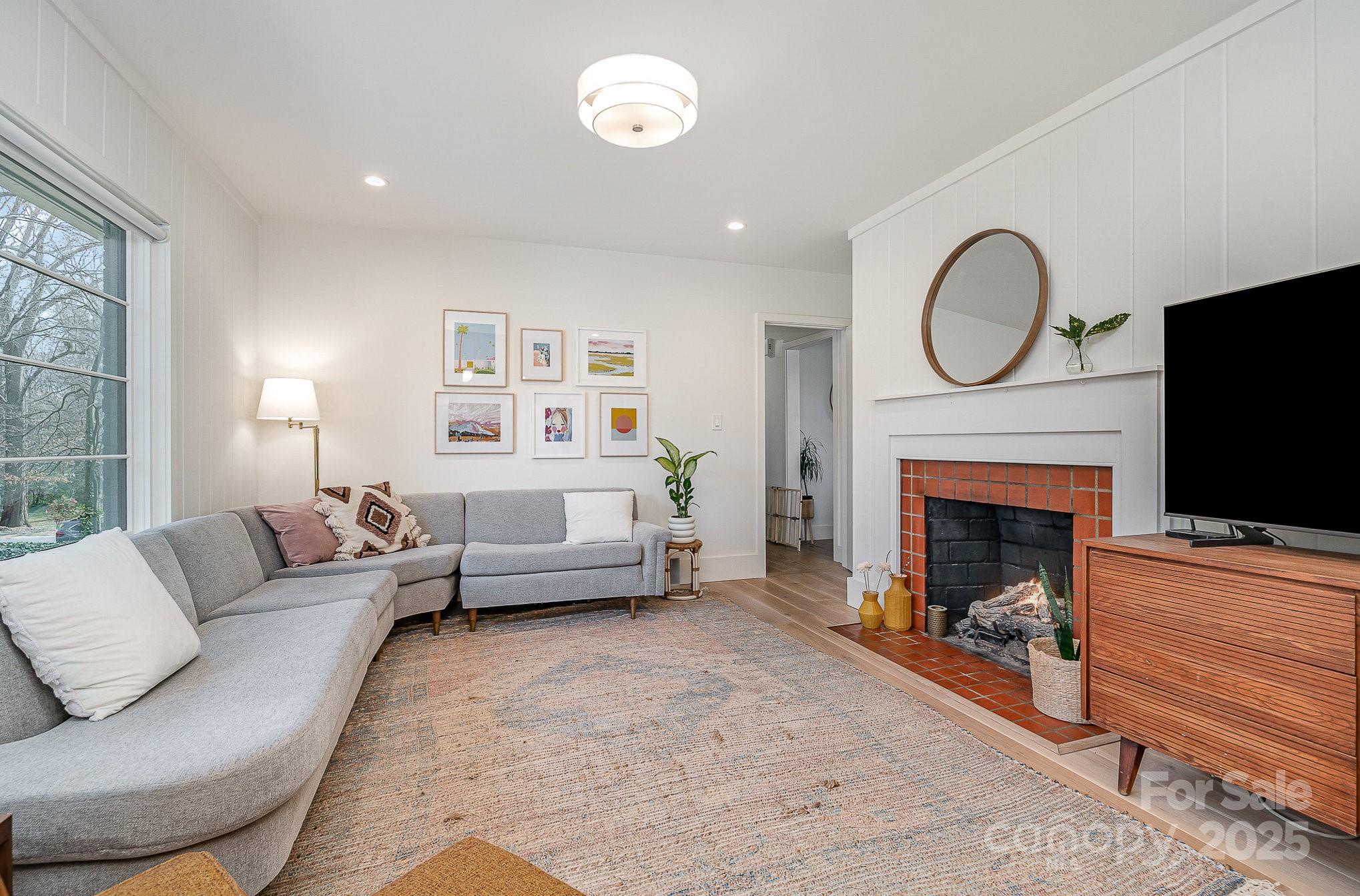 4833 Addison Drive Charlotte, NC 28211 - Photo 26 of 47 a living room with furniture a fireplace and a flat screen tv