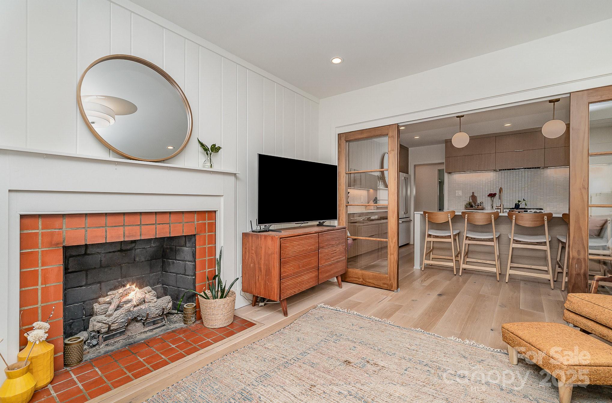 4833 Addison Drive Charlotte, NC 28211 - Photo 28 of 47 a living room with furniture a flat screen tv and a fireplace