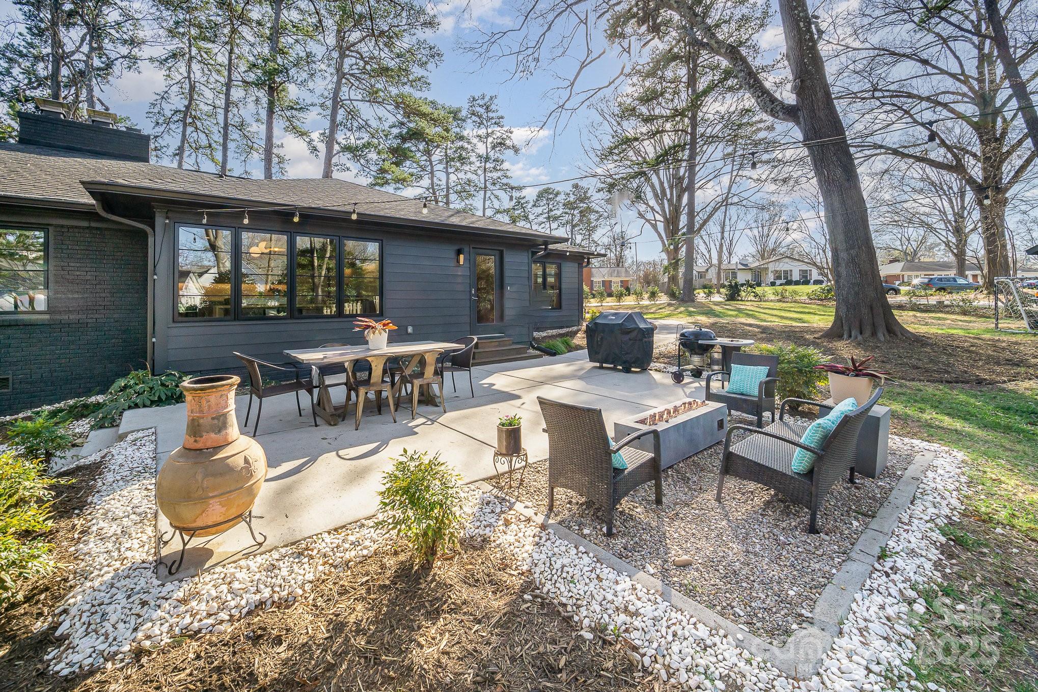 4833 Addison Drive Charlotte, NC 28211 - Photo 38 of 47 a view of a patio with couches table and chairs under an umbrella