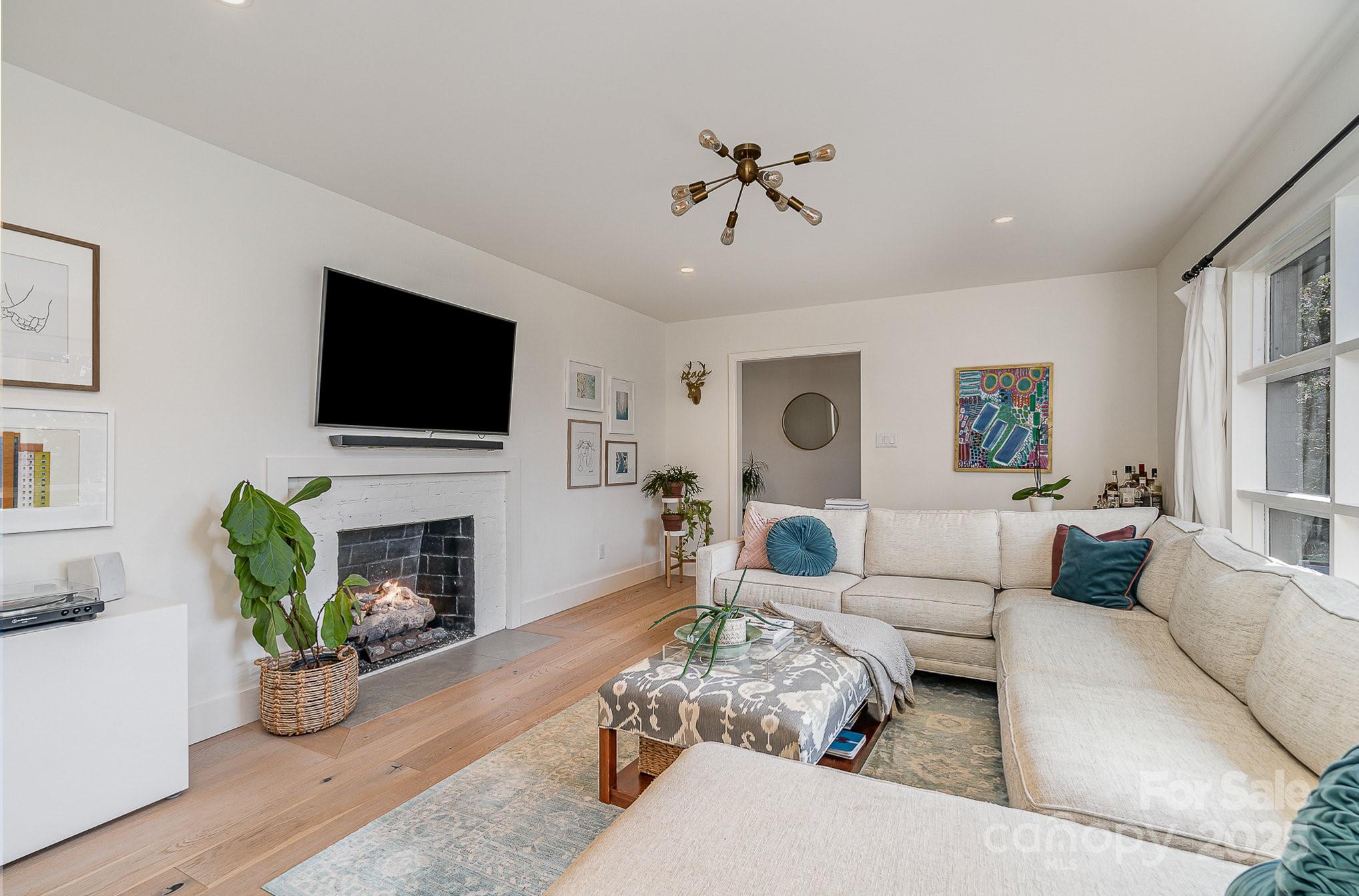 4833 Addison Drive Charlotte, NC 28211 - Photo 6 of 47 a living room with furniture a fireplace and a flat screen tv