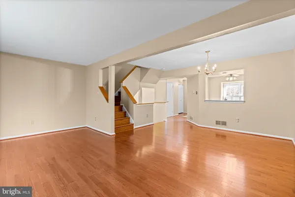 an empty room with wooden floor and staircase