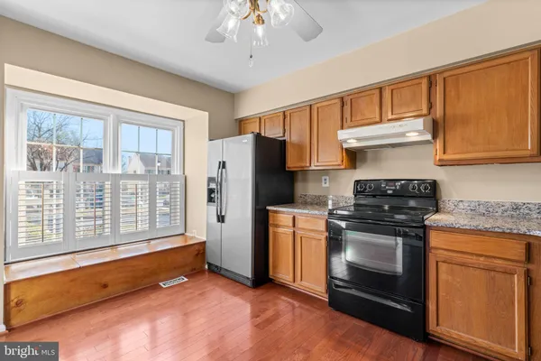 a kitchen with stainless steel appliances granite countertop a stove a refrigerator and a white cabinets