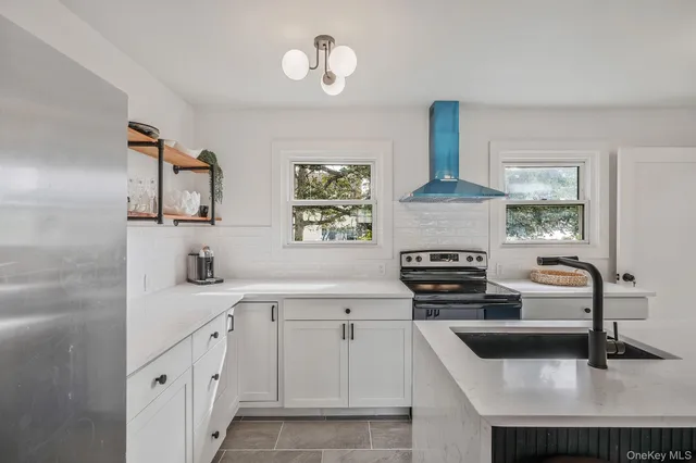 a kitchen with cabinets stainless steel appliances a sink and a stove