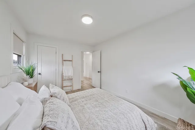 a bedroom with a bed and a potted plant