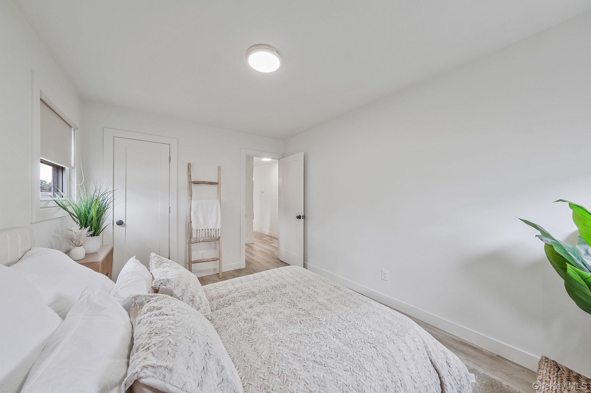120 Manhattan Avenue West Babylon, NY 11704 - Photo 22 of 32 a bedroom with a bed and a potted plant