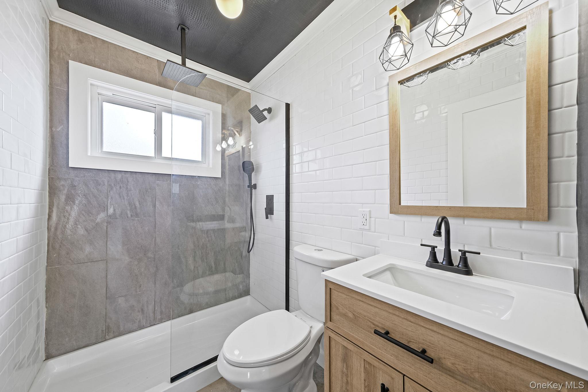 120 Manhattan Avenue West Babylon, NY 11704 - Photo 23 of 32 a bathroom with a sink a mirror a toilet and shower