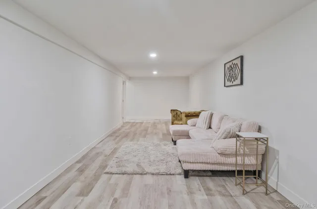 a view of a bedroom with wooden floor and lounge chairs