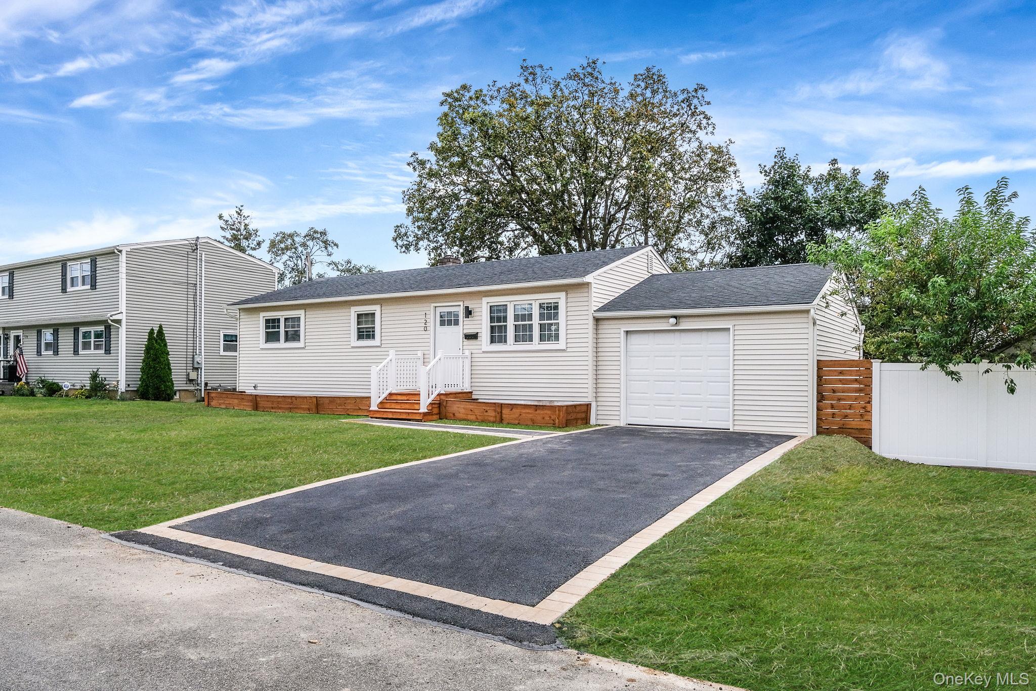120 Manhattan Avenue West Babylon, NY 11704 - Photo 3 of 32 a view of a yard in front of a house with plants and large tree