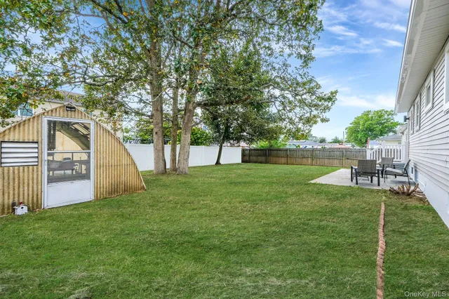 a view of a backyard with table and chairs and a small cabin