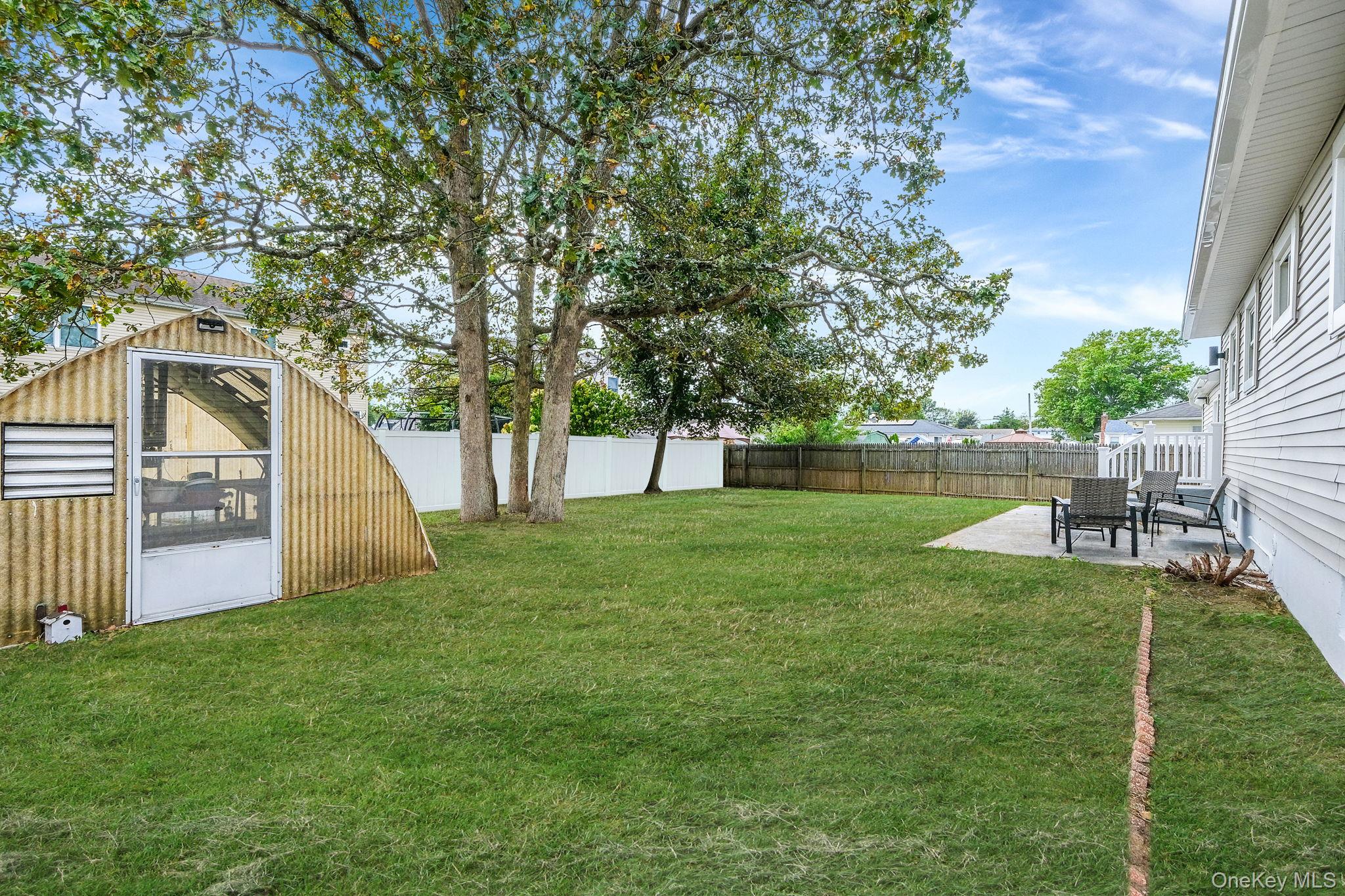 120 Manhattan Avenue West Babylon, NY 11704 - Photo 5 of 32 a view of a backyard with table and chairs and a small cabin