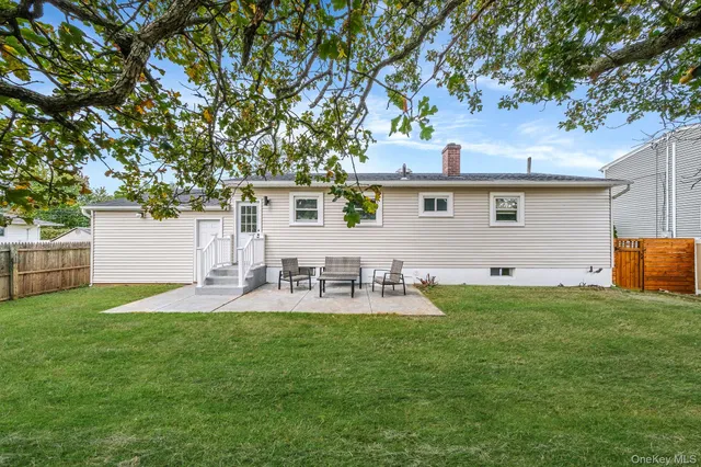 a view of backyard of house with outdoor seating and green space