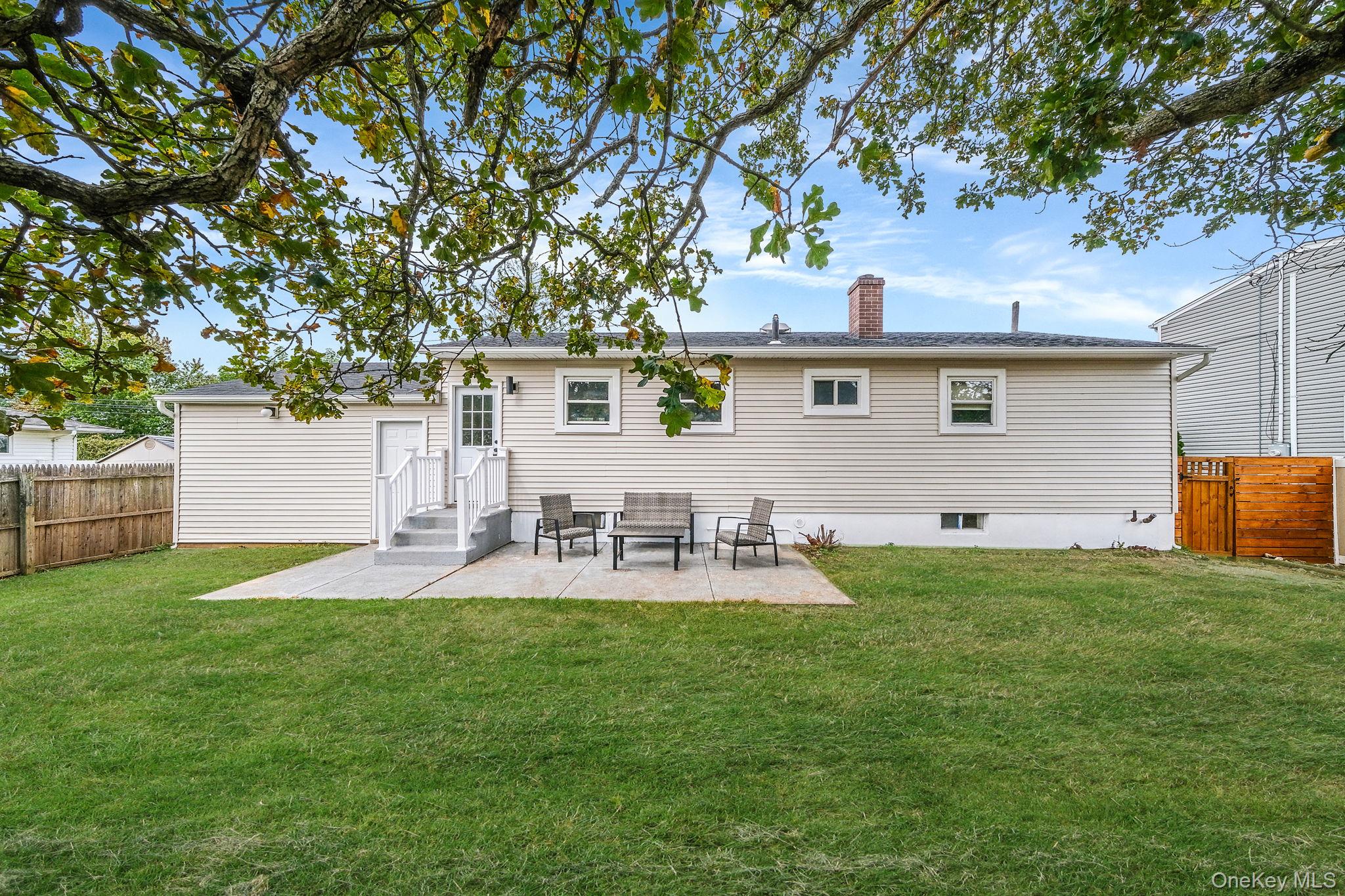 120 Manhattan Avenue West Babylon, NY 11704 - Photo 6 of 32 a view of backyard of house with outdoor seating and green space
