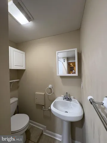 a bathroom with a toilet sink and mirror