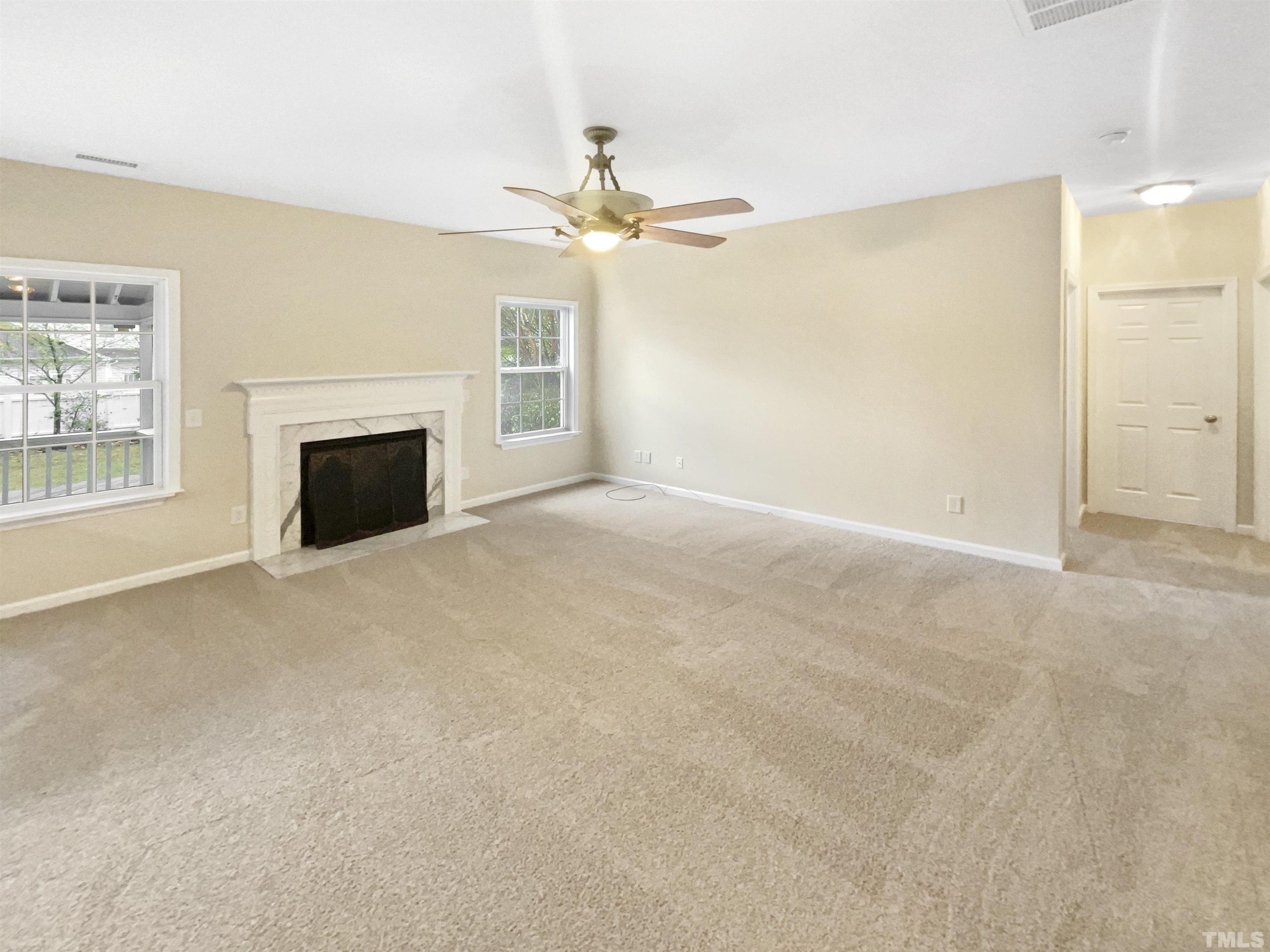 5408 Neuse Planters Court Raleigh, NC 27616 - Photo 2 of 17 an empty room with windows and fireplace