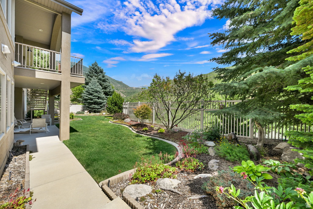 1926 East Gray Fox Drive Draper, UT 84020 - Photo 25 of 31 Landscaped backyard with mature trees, a manicured lawn, and mountain scenery.