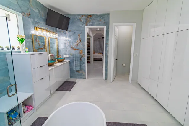 a living room with furniture a flat screen tv and a floor to ceiling window