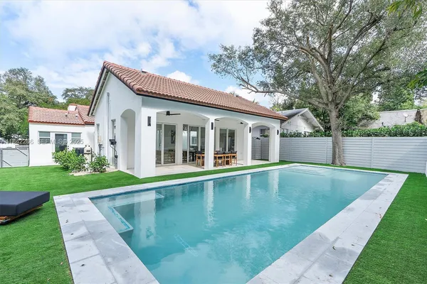 front view of a house with swimming pool and a yard