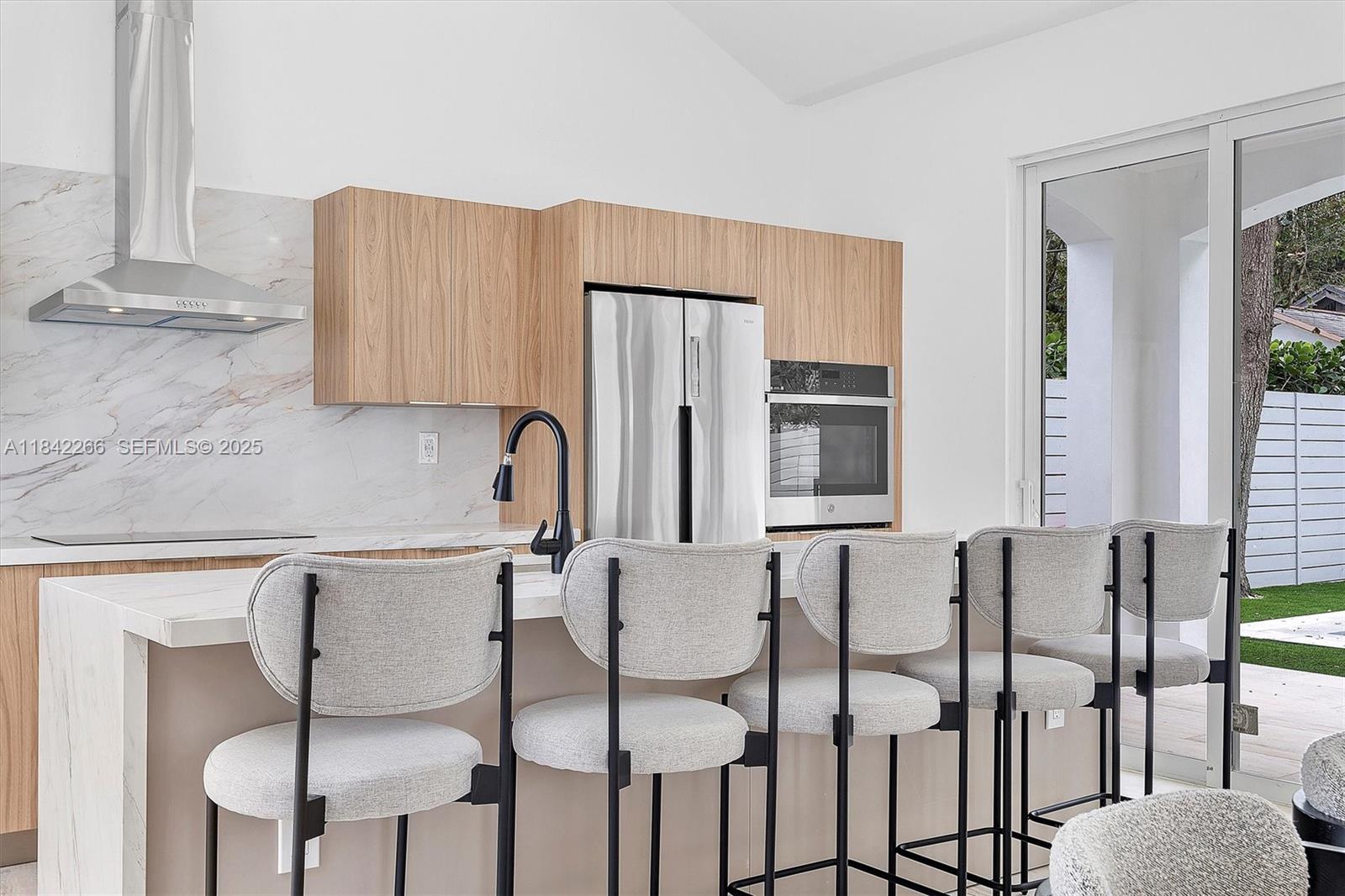 58 Northeast 45th Street Miami, FL 33137 - Photo 11 of 55 a kitchen with stainless steel appliances granite countertop a table chairs and a refrigerator