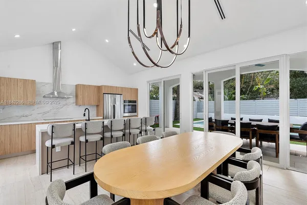 swimming pool view with a large dining table and chairs