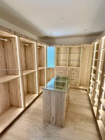 a kitchen with stainless steel appliances granite countertop a table chairs and a refrigerator