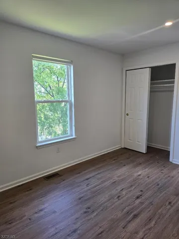 a view of a room with wooden floor and window