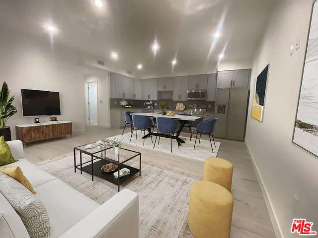 a kitchen with stainless steel appliances granite countertop a table chairs refrigerator and a stove top oven