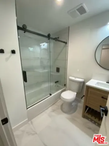 an empty room with wooden floor and sliding door