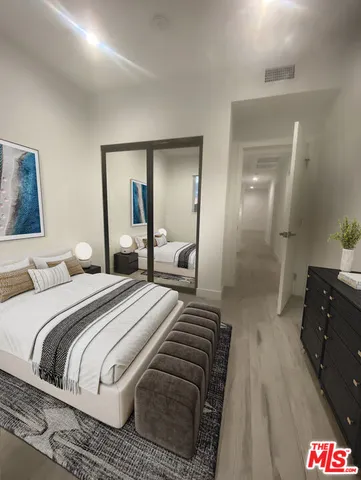 an empty room with wooden floor and mirror