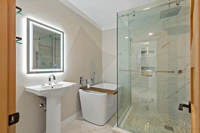 a bathroom with a sink a toilet and shower