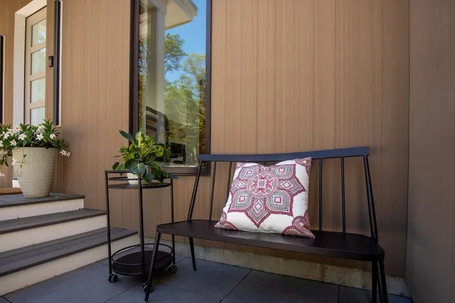 a view of a room with a chair and potted plant