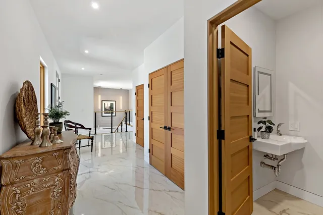 a living room with furniture a flat screen tv and a refrigerator