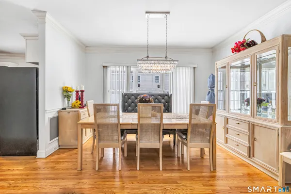 a view of a dining room with furniture a chandelier and wooden floor