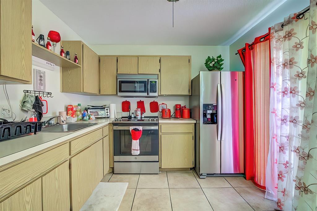 56 Pine Track, Unit 101E Ocala, FL 34472 - Photo 8 of 23 a kitchen with a refrigerator and a microwave